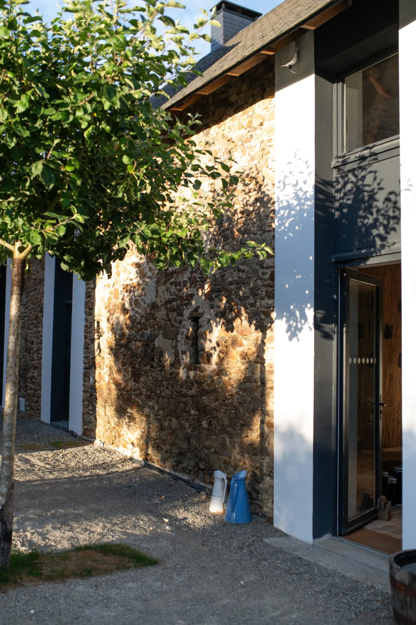 Sunlight and apple-tree shadows on the stone and white walls