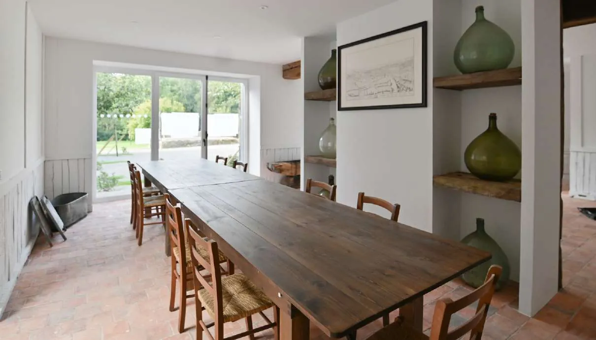 A long wooden table in a bright room, ready for a group