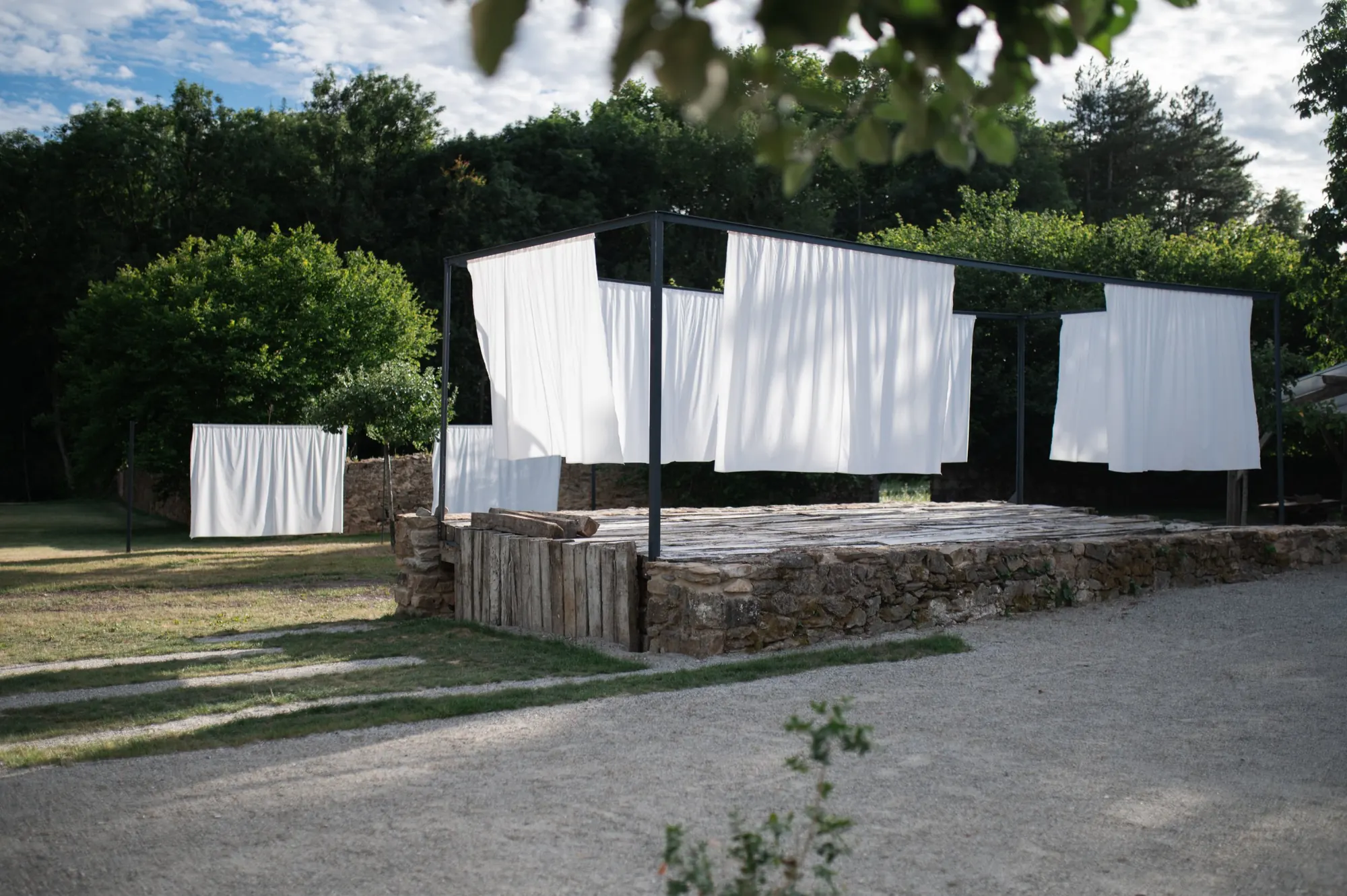 White curtains on a black metal frame in the garden