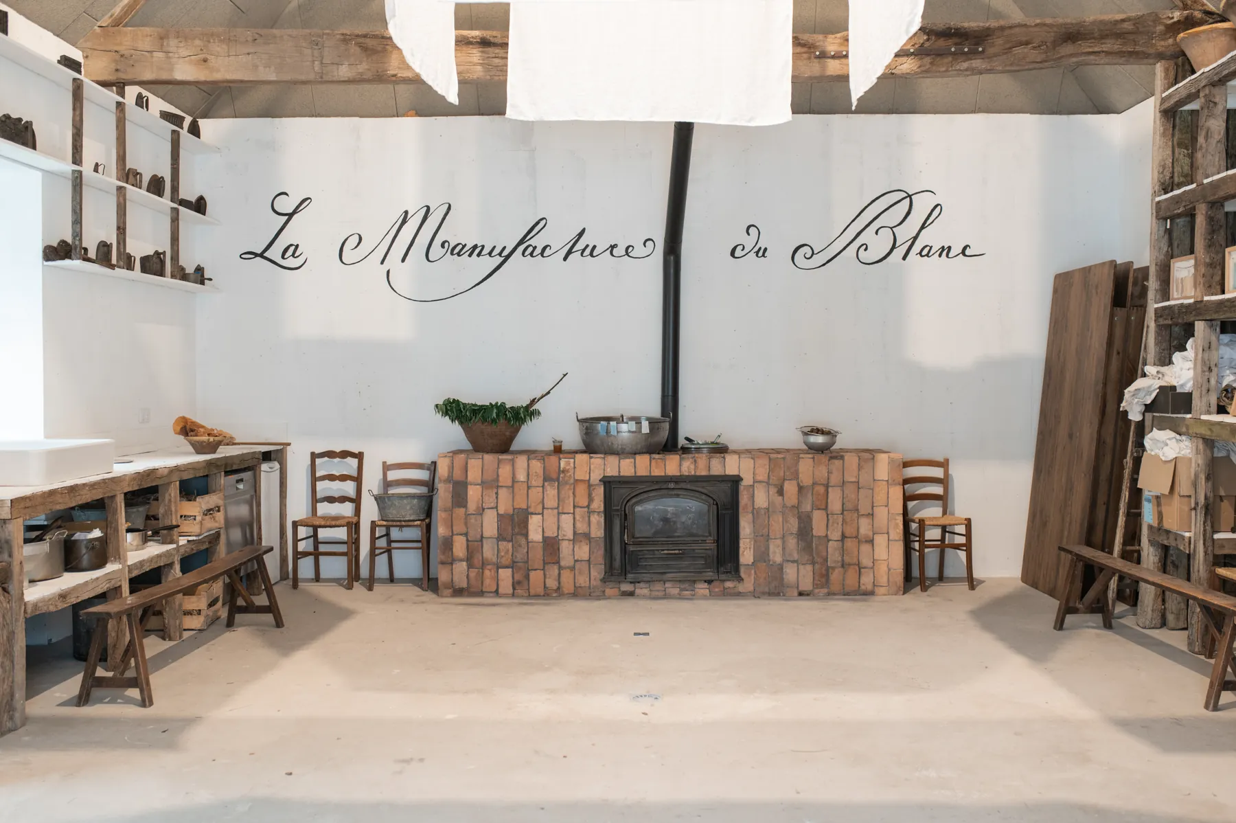 The workshop with its fireplace and the lettering La Manufacture du Blanc on the wall