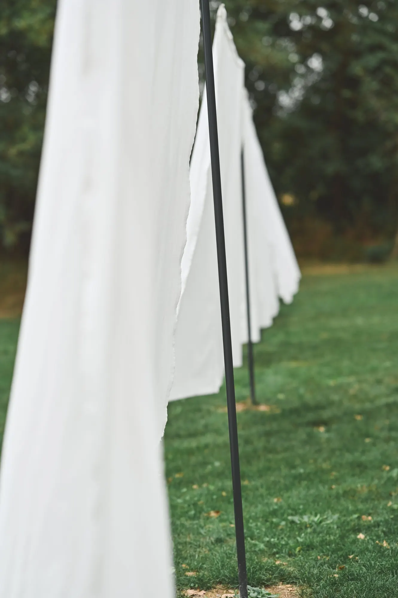 White linen hanging on poles across the lawn